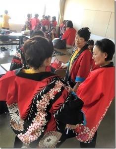 控室内にて談笑しながら赤い法被に着替える女性陣の写真